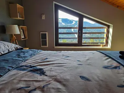 a bedroom with a bed and a large window at Nordic Sunset Retreat in Pamporovo