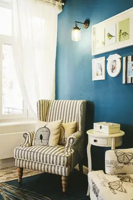 a living room with a chair and a blue wall at 5 Vintage Guest House in Sofia