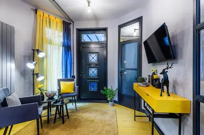 a living room with a yellow table and a tv at 5 Vintage Guest House in Sofia