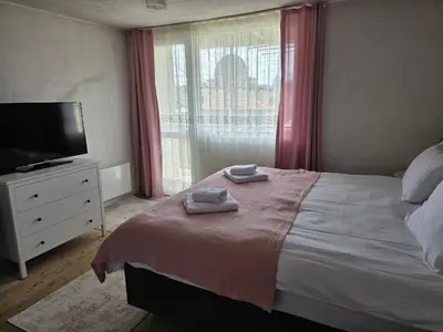 a bedroom with a bed and a tv and a window at Къща за гости ВИРА in Yasă-Koriya