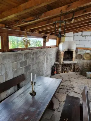 a wooden table in a room with a fireplace at Къща за гости ВИРА in Yasă-Koriya