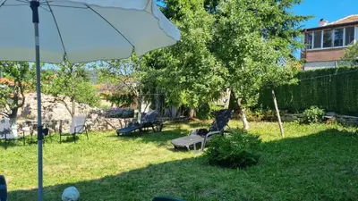 a yard with a statue of a bird sitting on a bench at Къща за гости ВИРА in Yasă-Koriya
