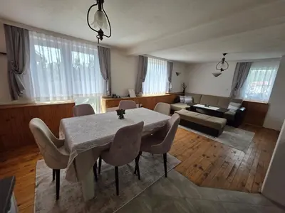 a living room with a table and chairs and a couch at Къща за гости ВИРА in Yasă-Koriya