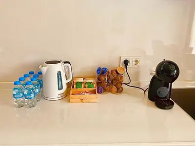 a counter with a coffee maker and bottles of water at SUGARFAME- Guest House in Sarnitsa