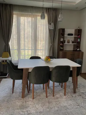 a dining room table with chairs and a white table at Luxury Park Villa in Sandanski