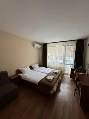 a bedroom with a bed and a couch and a window at Къща за гости Стефани in Devin