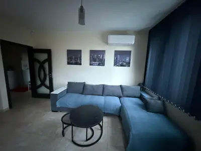 a living room with a blue couch and a table at Apartment near Vitosha mountain, self check-in, with underground parking in Sofia