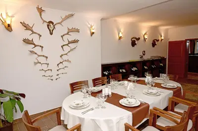 a dining room with tables and a heart shaped wall at Ловна резиденция ДЛС Извора in Devin