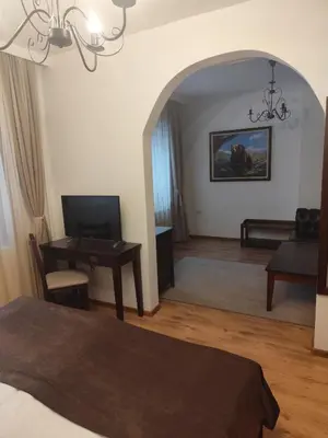 a bedroom with a bed and a desk with a table at Ловна резиденция ДЛС Извора in Devin