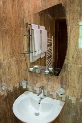 a bathroom with a sink and a mirror and towels at Ивелия Къща за гости in Dospat