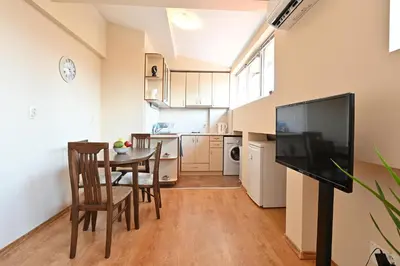 a kitchen and dining room with a table and a television at Studio KFC in Sofia