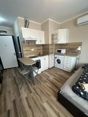 a kitchen with white cabinets and a table in a room at Mirror Residenced & private parking in Sofia