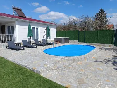 a patio with chairs and a swimming pool at Къщи за гости 