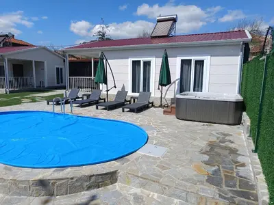 a backyard with a blue trampoline and a pool at Къщи за гости 