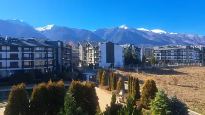 a city with buildings and trees and snow capped mountains at Pirin Views Aspen A337 in Razlog