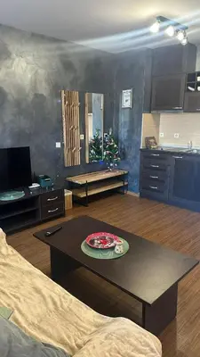 a living room with a table and a christmas tree at Eleonor Mountain Studio in Bansko