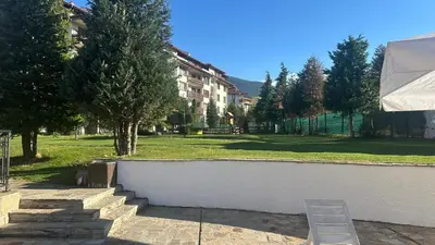 a white wall with a bench next to a park at Eleonor Mountain Studio in Bansko