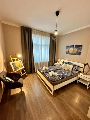 a bedroom with a bed and a chair in it at Superb 2 Bedroom Top Central Apartment in Sofia