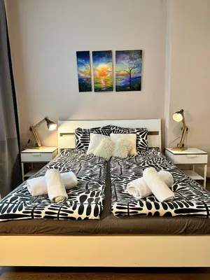 a bed with black and white sheets and pillows at Superb 2 Bedroom Top Central Apartment in Sofia
