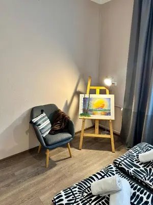 a room with a chair and a painting and a canvas at Superb 2 Bedroom Top Central Apartment in Sofia