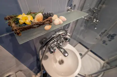 a bathroom with a sink and a shelf with shells at Little HoMe with a Park View by Flat Mаnager in Sofia
