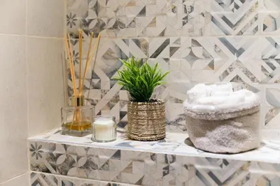a bathroom with a shelf with towels and a plant at Artistic and cozy apartment in the center of Sofia in Sofia
