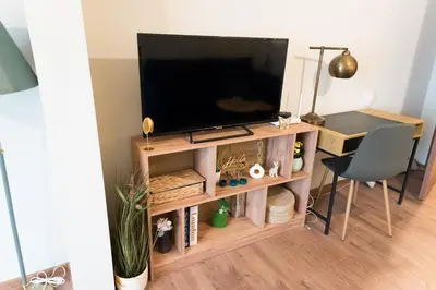 a television on a wooden stand in a living room at Artistic and cozy apartment in the center of Sofia in Sofia