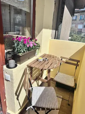 a small table and chairs on a balcony with flowers at Artistic and cozy apartment in the center of Sofia in Sofia
