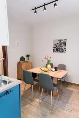 a kitchen with a wooden table with chairs and a dining room at Artistic and cozy apartment in the center of Sofia in Sofia