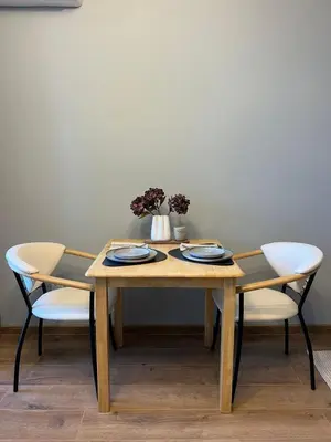 a wooden table with two chairs and a vase with flowers at Studio79 in Plovdiv