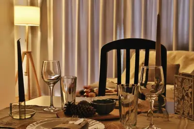 a dining room table with wine glasses and a chair at Gardenia Apartment Pamporovo in Pamporovo