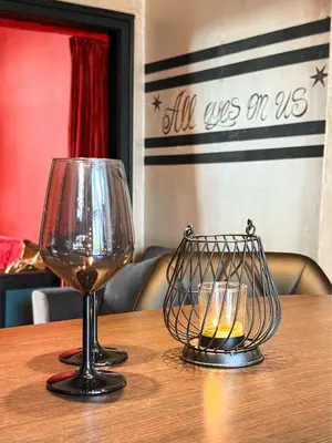 two wine glasses and a candle holder on a table at Sofia's Gem Apartment - Prime Location in Sofia