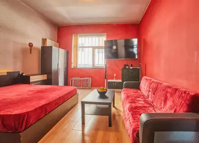 a red room with a bed and a couch at Sofia's Gem Apartment - Prime Location in Sofia