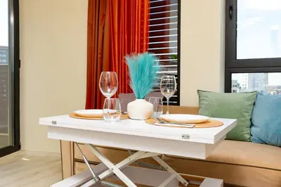 a white table with two glasses and a couch at City Park flat near to Medical University in Plovdiv