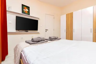 a bedroom with a bed with a flat screen tv at City Park flat near to Medical University in Plovdiv
