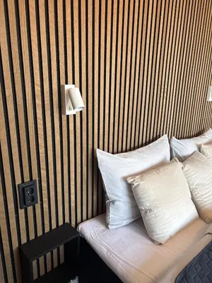 a bed with white pillows and a striped wall at Kolev Apartment 1 in Sofia