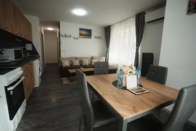 a kitchen and living room with a wooden table in a room at Royal nest in Sofia