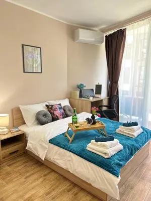 a bedroom with a bed with a table on it at Rea Elita - Fresh and Modern Studio in Sofia
