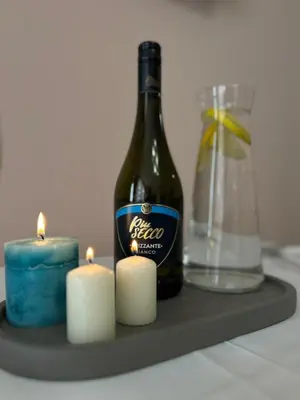 a bottle of wine and candles on a tray at Rea Elita - Fresh and Modern Studio in Sofia