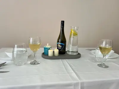 a table with a bottle of wine and two glasses at Rea Elita - Fresh and Modern Studio in Sofia
