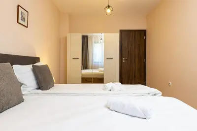 a bedroom with two beds with white sheets and a mirror at Central Lovely apartment Venu close to Old Town in Plovdiv