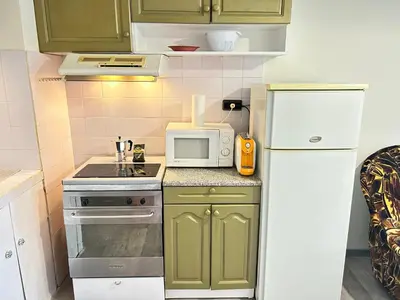 a small kitchen with green cabinets and a white refrigerator at River Nest in Plovdiv