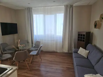 a living room with a couch and a table and chairs at Тристаен апартамент in Elin Pelin