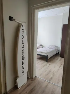 a surfboard leaning against a wall in a room at Тристаен апартамент in Elin Pelin