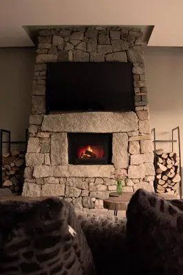 a stone fireplace with a tv on top of it at Luxury House Veles in Hisarya