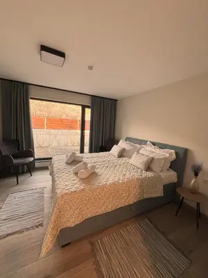 a bedroom with a large bed and a large window at Luxury House Veles in Hisarya
