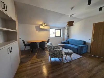 a living room with a blue couch and a table at KS Gondola point apartment in Bansko