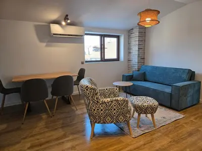 a living room with a couch and chairs and a table at KS Gondola point apartment in Bansko