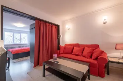 a living room with a red couch and a bed at LZ Spacious One Bedroom Apartment in Top Centre by Flat Mаnager in Sofia