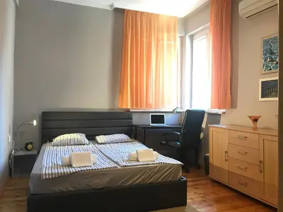 a bedroom with a bed and a desk and a window at Beautiful Business Apartment - Ivan Denkoglu Street by Flat Mаnager in Sofia